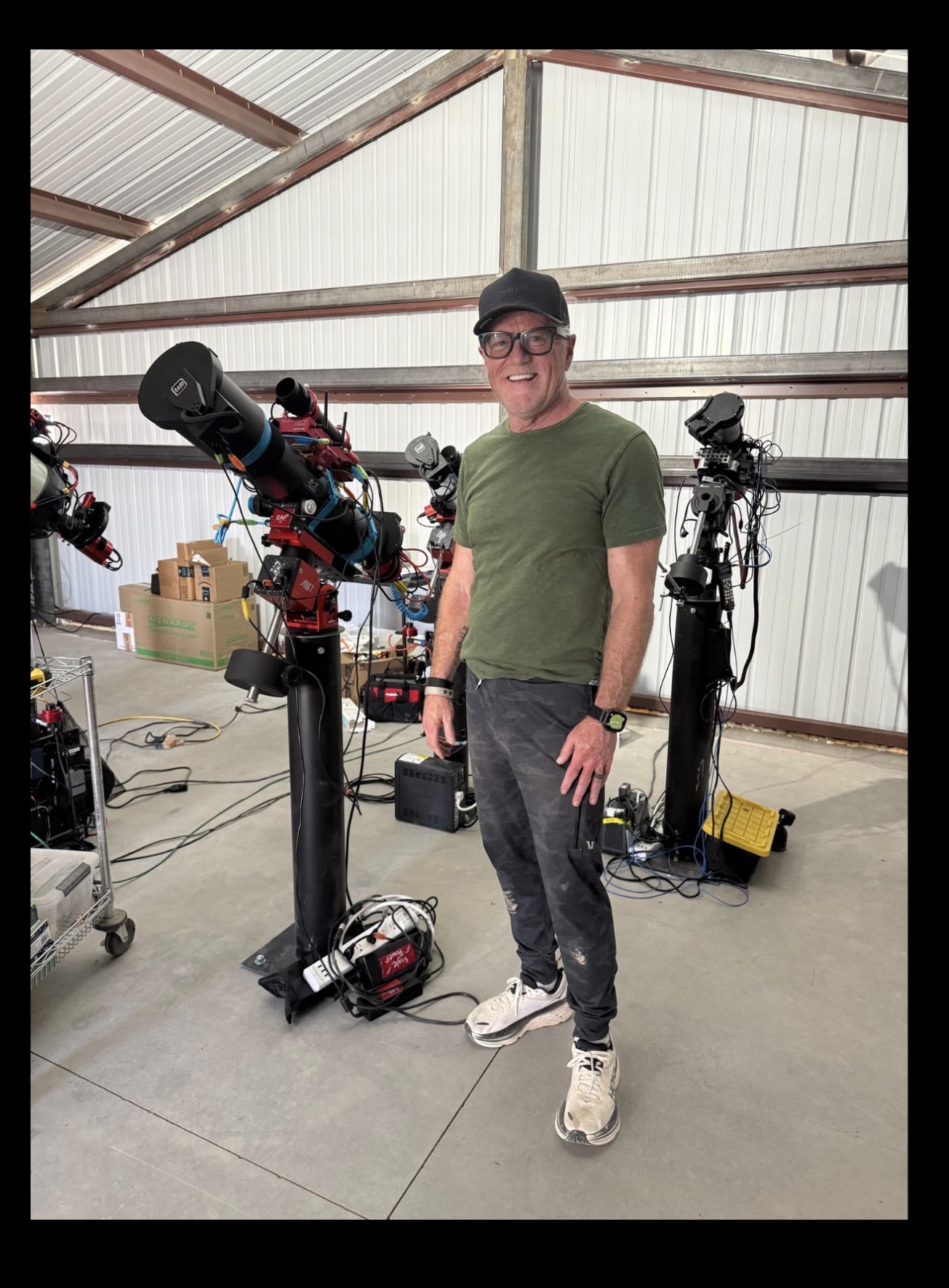 Shawn Gurley standing with astrophotography equipment in his observatory