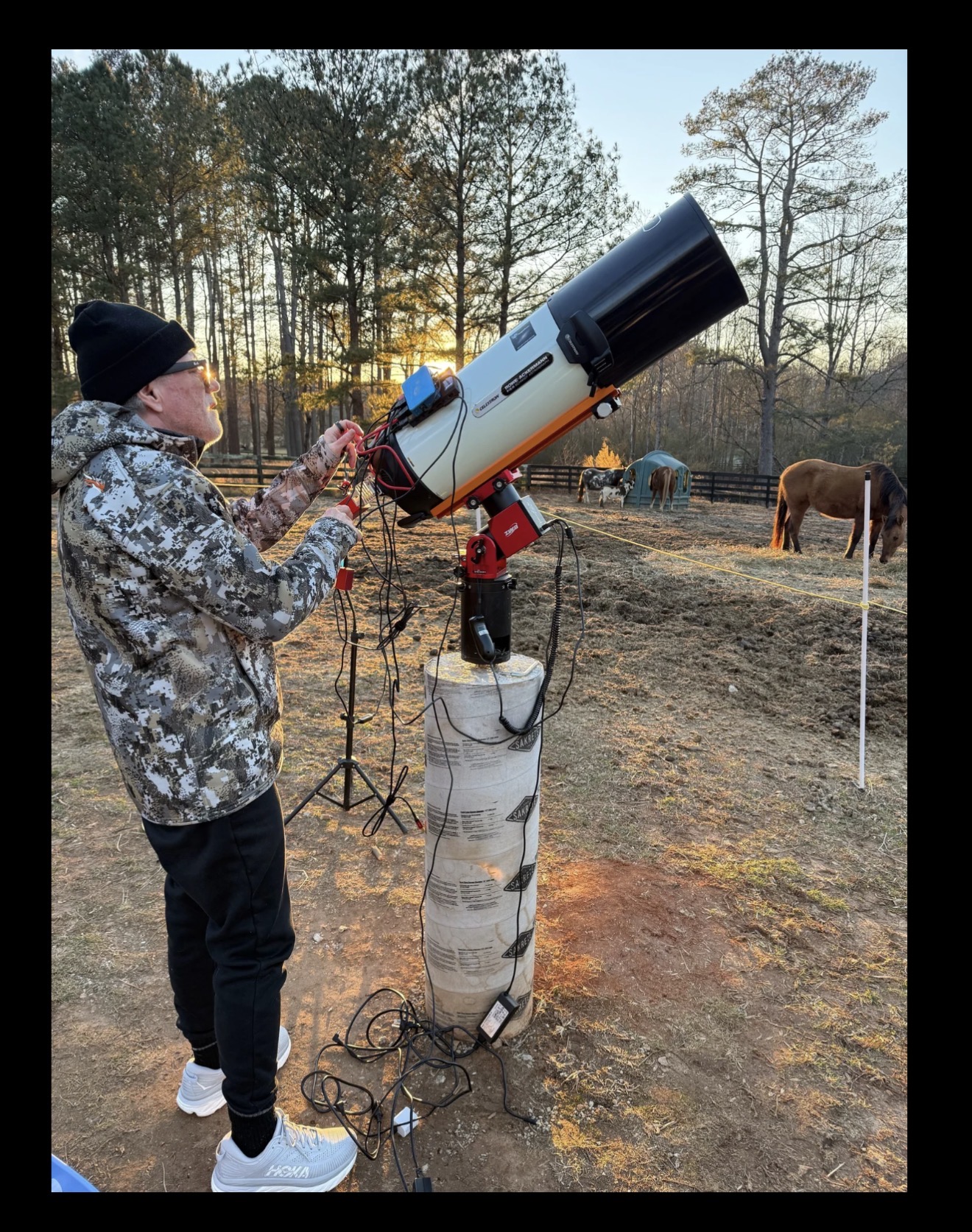 Shawn Gurley preparing a large telescope outdoors before sunset